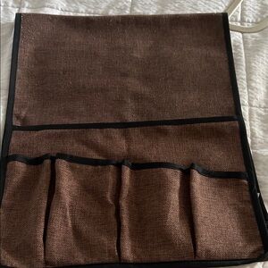 Brown over the arm catch all for remote , newspaper and magazines